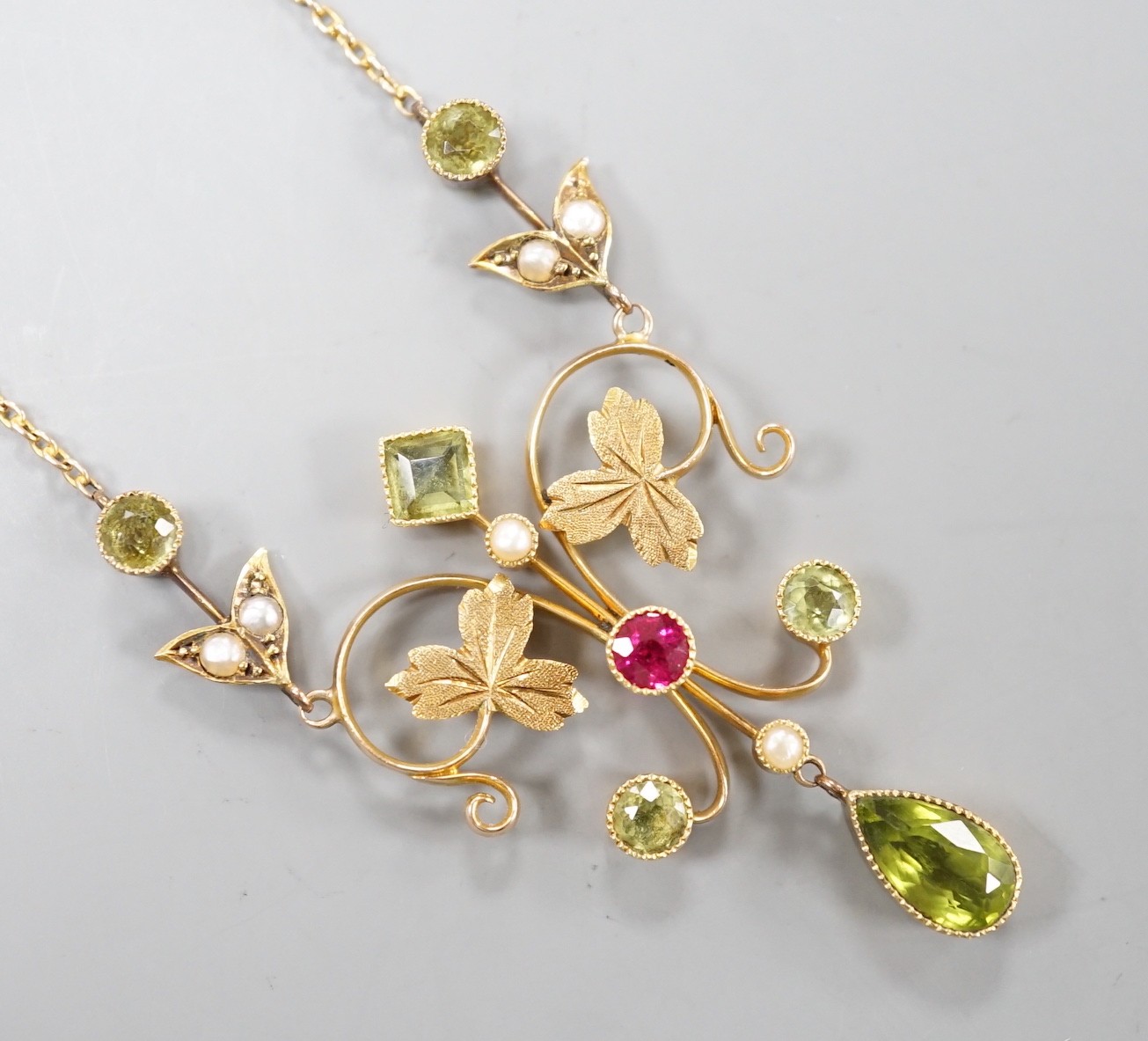 An Edwardian 15ct, peridot, seed pearl and ruby set drop pendant necklace, 46cm, gross weight 6.9 grams.